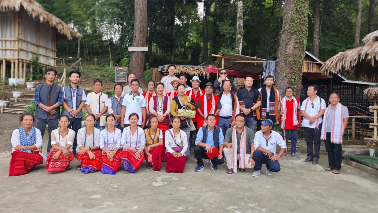 Foundation members in traditional attire gathered at a heritage village