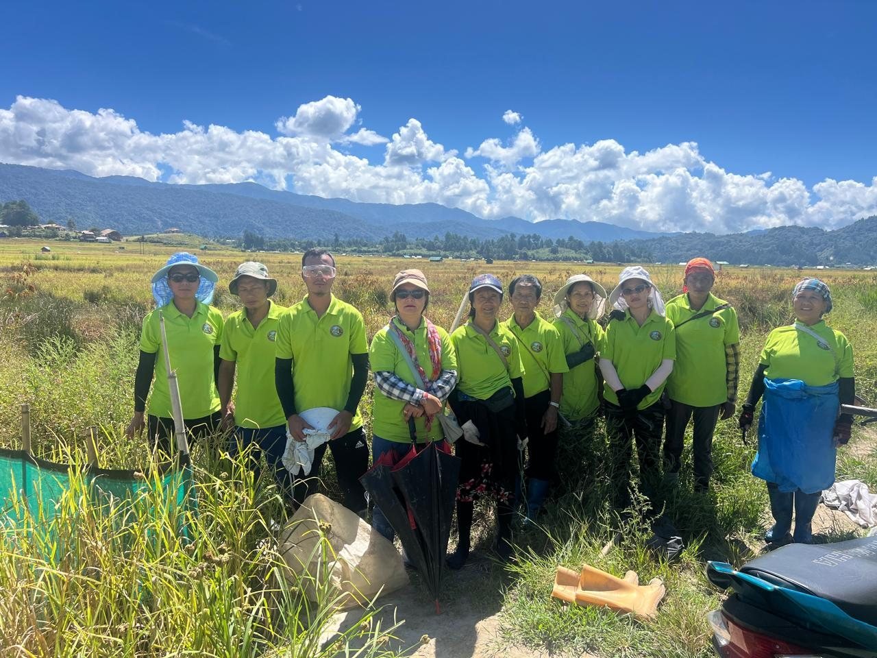 Volunteers in matching shirts standing together in a field